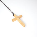 Side view of the wooden cross necklace displaying its thickness