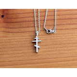 Saint Andrew Cross Sterling Silver Pendant and 18 Inch Chain on a wooden table
