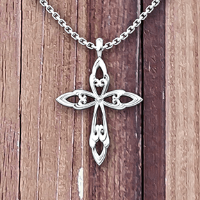 Leaf Cross Sterling Necklace with 18 inch chain on a wooden table 