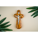 Catholic crucifix holding cross laid flat among palm fronds