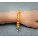 Olive Wood Stretch Bracelet, Yellow Beads and Cross Dangle on female wrist