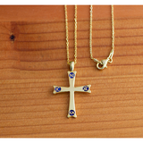 Mount Sinai Cross Gold-Plated Sterling Silver Pendant - 18 Inch Chain on a wooden table 